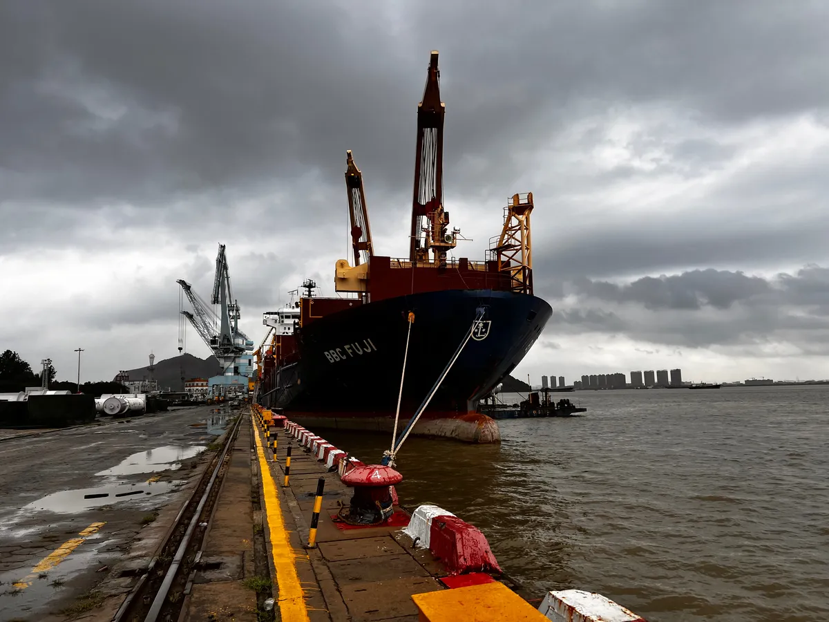 Heavy-lift cargo vessel alongside an industrial berth
